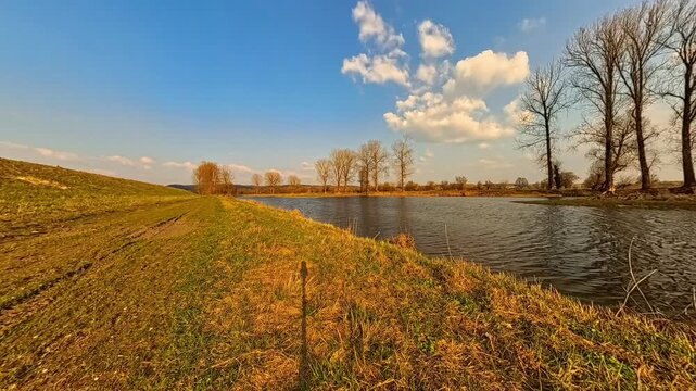 4K Timelapse video with reflections and moving waters of a pond and moving clouds near Arbing, Osterhofen, Deggendorf, Bavaria, Germany