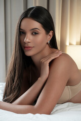 Fototapeta premium A beautiful girl in sexy lingerie poses on the bed in the bedroom