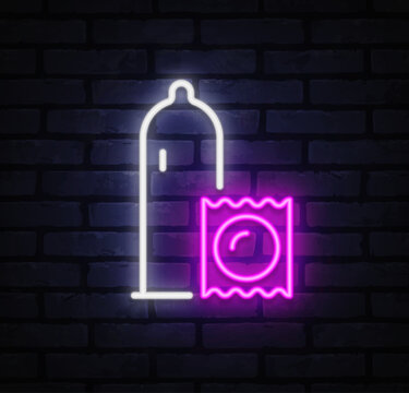 Neon condom and wrapper icon glowing in pink and white on dark brick wall. Bold minimal design highlights safe intimacy concept. Ideal for pharmacy ads, health campaigns