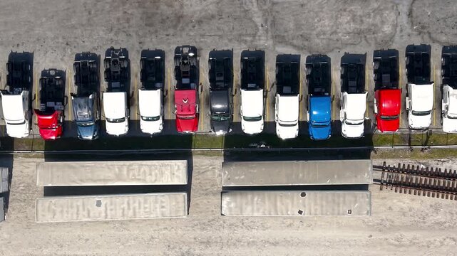 Aerial top down view of parked colorful semi trucks in a lot