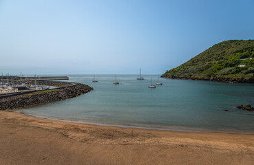 Fototapeta premium Exposure of the Prainha beach, prefect for a swim in the calm waters, located in the Terceira Island, just in the city center, near the Marina and the Fortress, Azores, Portugal