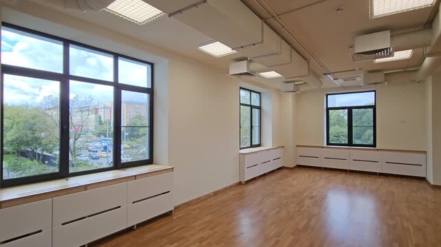 MOSCOW - AUG 25, 2025: Large empty room with a wooden floor and a mirror. The room is empty and has a very clean and simple appearance