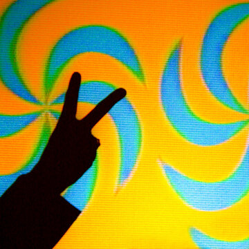 Hand Peace Sign Silhouette Against Psychedelic Retro 60s Background