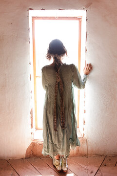 Silhouette of Woman Standing in Window with Soft Natural Light
