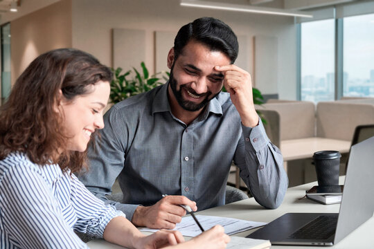 Two happy diverse business people professional employees workers having discussion working together having fun at office meeting. Indian teacher and latin student having friendly conversation.