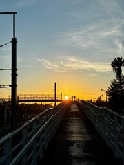 Two people silhouette on bridge at golden sunset, Lisbon Portugal © Ana