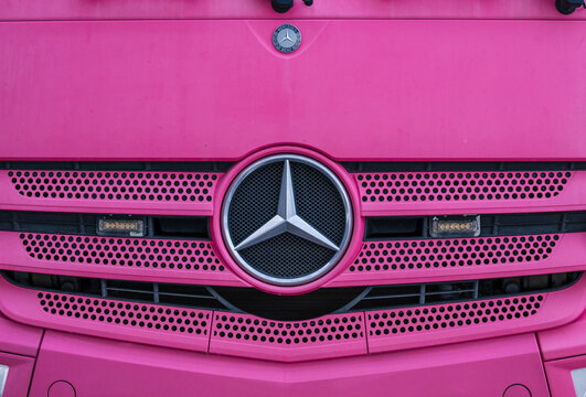 Gothenburg, Sweden - February 13 2026: Close up of bright pink Mercedes Benz truck front grille and emblem detail.
