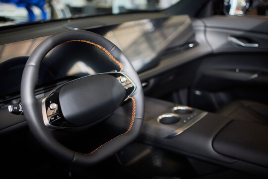 Closeup of a modern car steering wheel with control buttons for technology and convenience