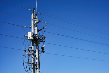 Electricity power line pole and transformer against a clear blue sky background © Vivid Moments