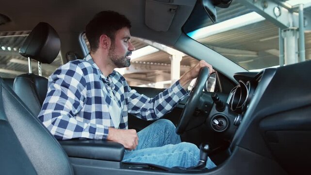 Happy young man ready to make first test drive. Slow motion