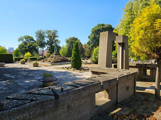 Fototapeta premium Cemetery with a stone wall and a stone archway. The archway is open and the cemetery is empty