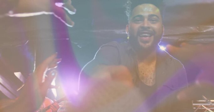 Male musicians reaching toward camera on stage, with animated music notes over LED screen visuals