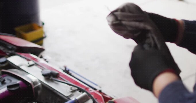 Animation of shapes over caucasian male mechanic reapiring car