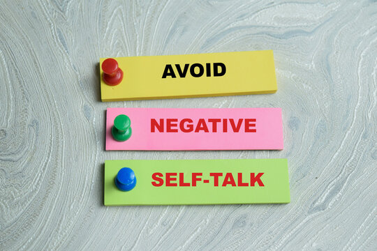 Concept of avoid negative self-talk write on sticky notes isolated on Wooden Table.
