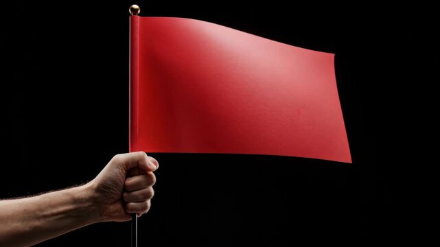 Hand Holding a Red Flag: A strong hand firmly grips a small, vibrant red flag against a dark backdrop.