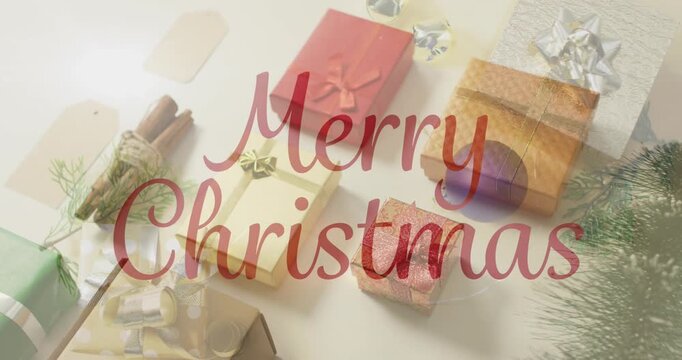 Animation of christmas greetings text over christmas presents and decorations