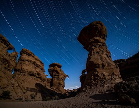 Nightscape of Kaluts yardangs in Lut Desert Iran with horizontal star trails. Sharp sand ripples, Gandom Beryan volcanic stones, and deep focus with copy space. Desert nature concept.