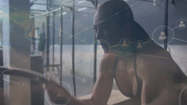 Athlete leaning on plyo box, reaching to left monitor starting network overlay showing fitness data