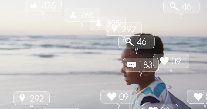 Schoolboy running along shore, playing while social alerts rising from bottom frame surrounding him