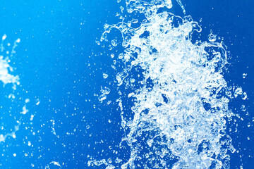 公園の噴水の水のアップと青い紙の背景 爽やかで涼しいイメージ