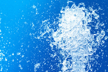 公園の噴水の水のアップと青い紙の背景 爽やかで涼しいイメージ