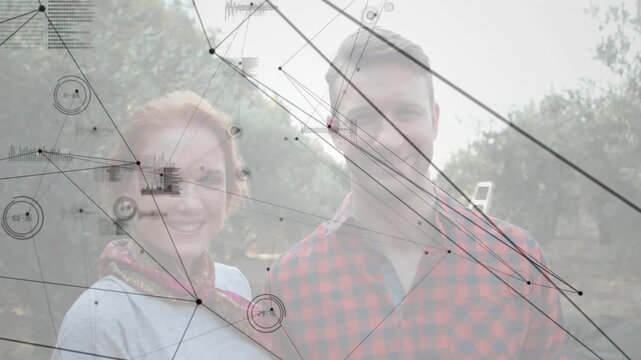 Couple standing at dawn in orchard witnessing data grid forming above them for agtech insights