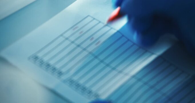 Medical technician verifying COVID-19 virus test result data on a clipboard in the lab, Berlin, Germany,