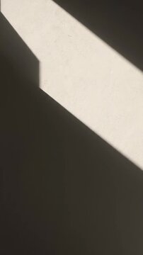 Dynamic interplay of shadows and light across textured wall creates an abstract visual expression highlighting geometric forms and architectural aesthetics.