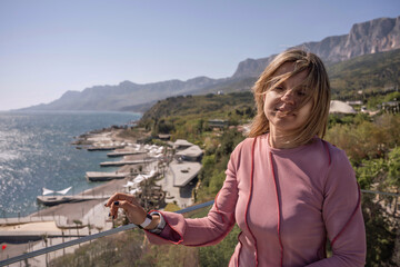 Fototapeta premium Woman pink shirt mountains enjoying sunny view of seaside resort and cliffs