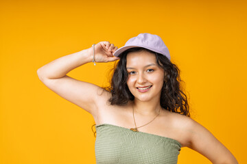 Fototapeta premium Young woman confidently wearing cap and smiling