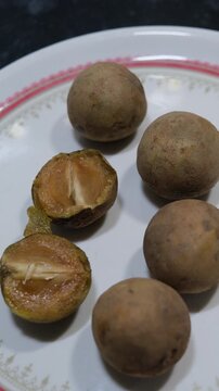 Ripe Sapota fruit cut open showing brown juicy pulp and seeds