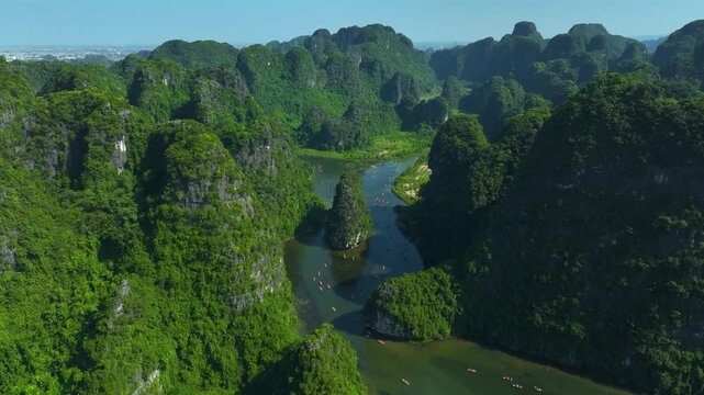Aerial drone view of Trang An landscape with limestone karst mountains and river in Ninh Binh, Vietnam.
