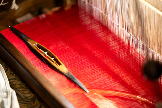 Traditional Sichuan Brocade Weaving Shuttle on Red Silk Loom at Chengdu Shu Brocade Museum, Intangible Cultural Heritage Craft