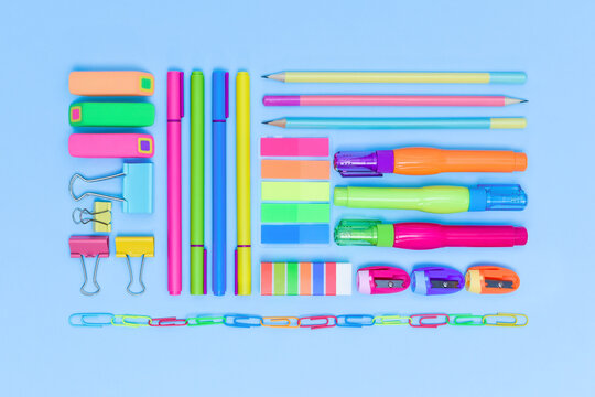 Assorted office and school colourful stationery supply on blue background as knolling.