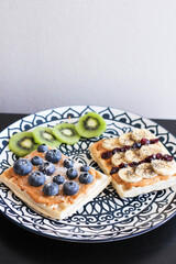 Healthy vegan waffles with peanut butter, banana and fresh fruit © Mariana
