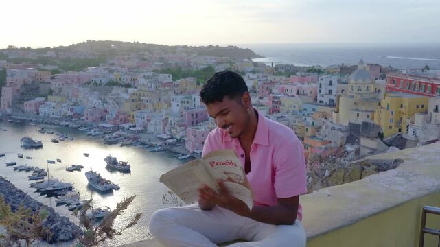 Smiling traveler reading a book overlooking colorful Procida harbor, Italy