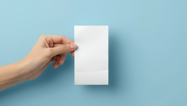 A hand with a blank receipt against a blue backdrop, simple mockup for financial documents and designs