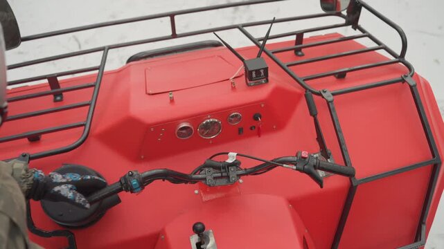 Pov helmeted rider on red atv plowing through snow hands on handlebar dashboard and front rack visible crisp cold light camouflage jacket white helmet closeup throttle motion intense adrenaline