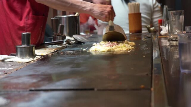 Traditional Japanese food okonomiyaki preparation scene