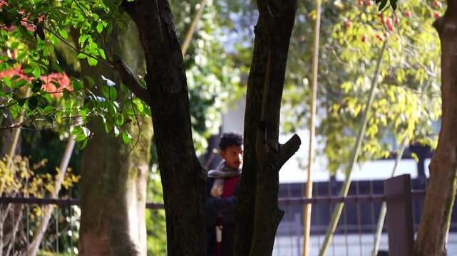 Young man standing in nature surrounded by trees