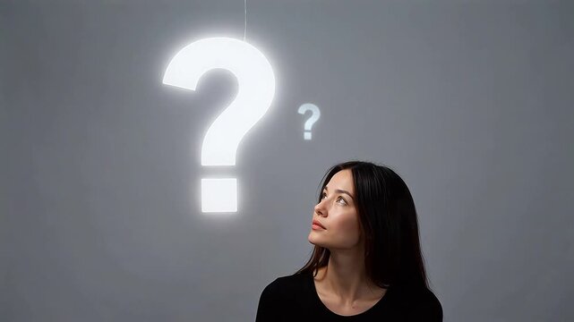 Woman looking at large glowing question mark