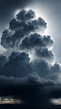 Dramatic Storm Cloud Formation with towering cumulus clouds and bright rim lighting against a dark sky, perfect for weather forecasting backgrounds and Vertical. Video. Portrait Orientation.