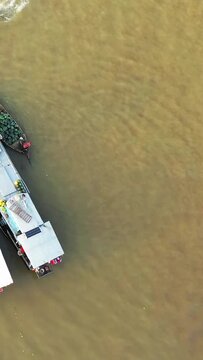 Top-down drone shot of boats docked on the river at the Cai Rang floating market in Vietnam, highlighting the vibrant market activity on the water.