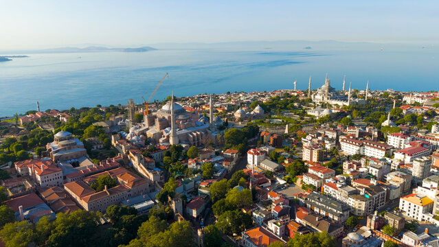 Istanbul, Turkey. Drone flyaway from Hagia Sophia to panoramic view with Blue Mosque and Sultanahmet Square rooftops and sea. Aerial View