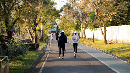 Obraz premium Life lifestyle thai people and fitness enthusiast training jogging and walk run exercise workout in Somdet Phra Srinagarindra Park or Suan Somdet Ya Public Garden at Pak Kret in Nonthaburi, Thailand