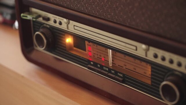 Close up shot of vintage radio tuner with glowing display and dial