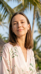 Beautiful woman portrait showing calm peaceful face outdoors during tropical summer vacation finding relaxation in nature feeling serene and highly confident near green palm tree
