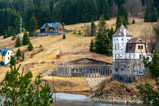 Labsk&aacute; Dam in &Scaron;pindlerův Ml&yacute;n, historic warden house with stone tower, Czech Krkono&scaron;e mountains, mountain architecture by frozen lake, tourism in Czech Republic, early spring landscape by Elbe river.