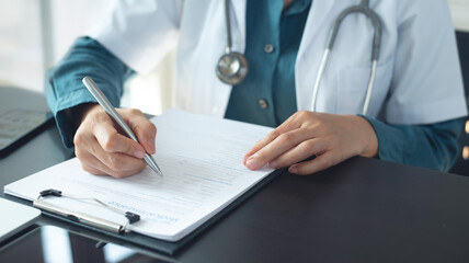 Fototapeta premium Doctor writing insurance and claim form for medical paperwork, document and script for patient records in a hospital. doctor planning healthcare, medical prescription