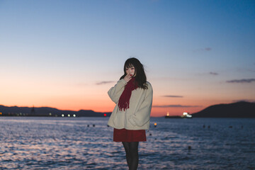 Fototapeta premium 夕暮れの海にいる女性